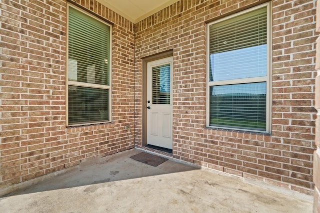 doorway to property with brick siding