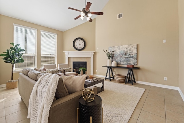 living area featuring visible vents, baseboards, ceiling fan, light tile patterned floors, and a tile fireplace