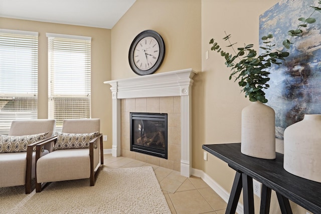 sitting room with tile patterned flooring, a tiled fireplace, and baseboards