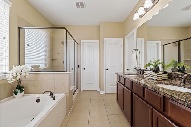 bathroom with tile patterned floors, a garden tub, visible vents, and a sink