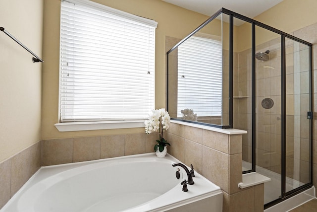 full bathroom featuring a bath and a stall shower