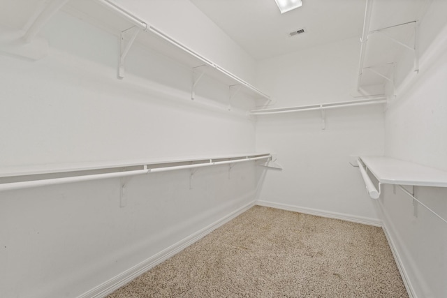 spacious closet featuring visible vents and light colored carpet