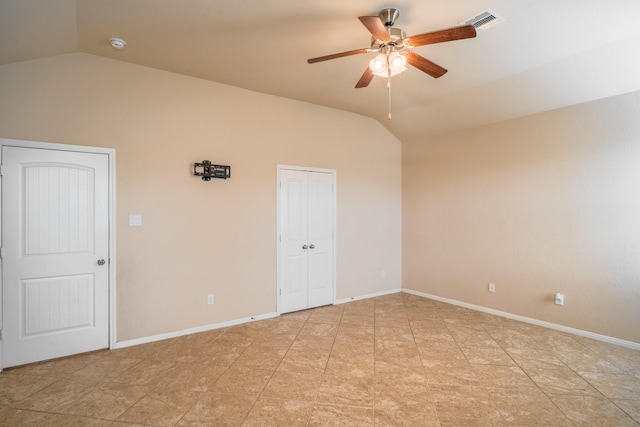 unfurnished room featuring vaulted ceiling, baseboards, visible vents, and ceiling fan