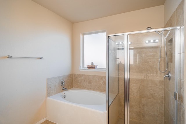 bathroom featuring a shower stall and a bath