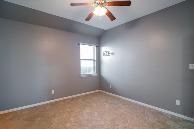 spare room featuring vaulted ceiling, baseboards, and ceiling fan