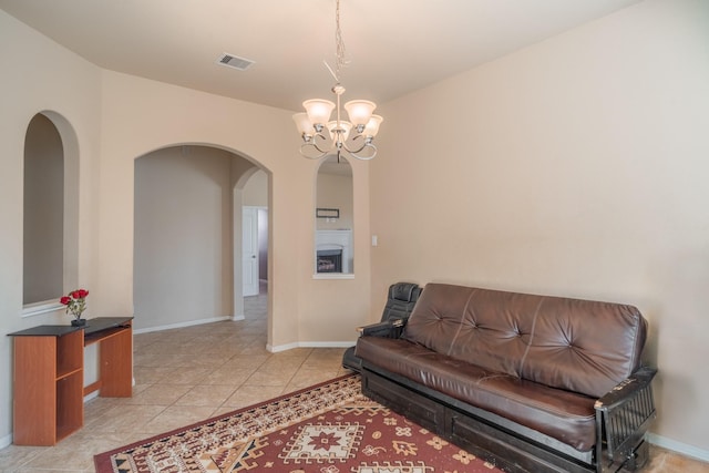 living room with light tile patterned floors, baseboards, visible vents, arched walkways, and a chandelier