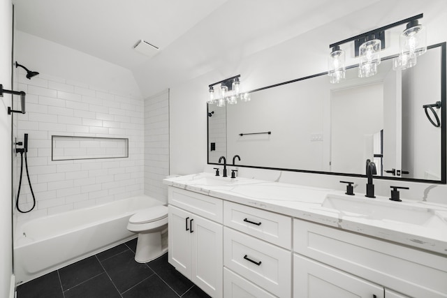 bathroom featuring tile patterned flooring, double vanity, toilet, and a sink