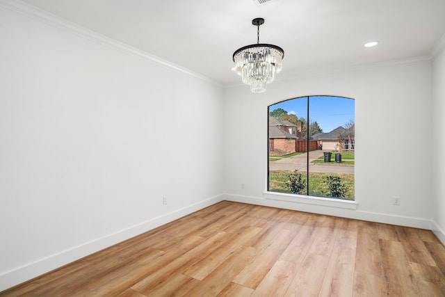 spare room with wood finished floors, baseboards, recessed lighting, crown molding, and a notable chandelier