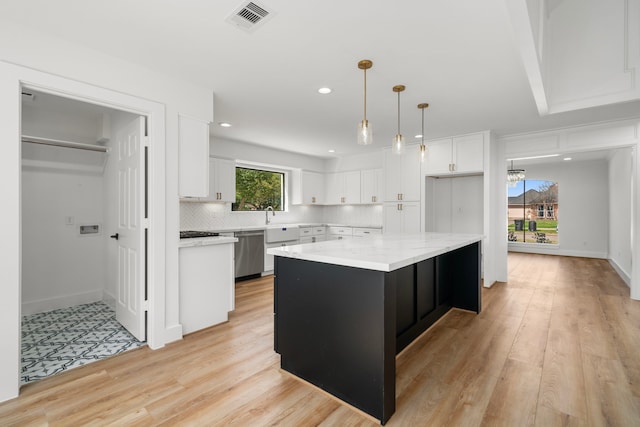 kitchen with light wood finished floors, visible vents, dishwasher, decorative backsplash, and white cabinets