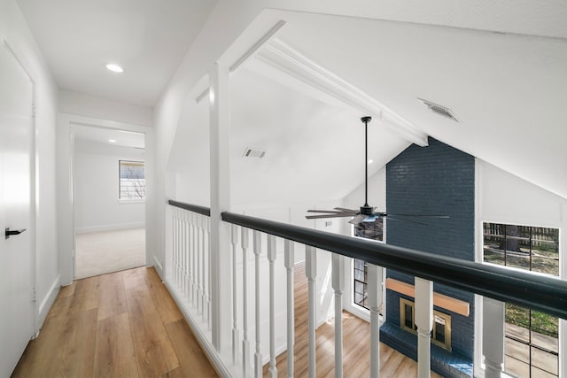 corridor featuring vaulted ceiling with beams, wood finished floors, visible vents, and baseboards