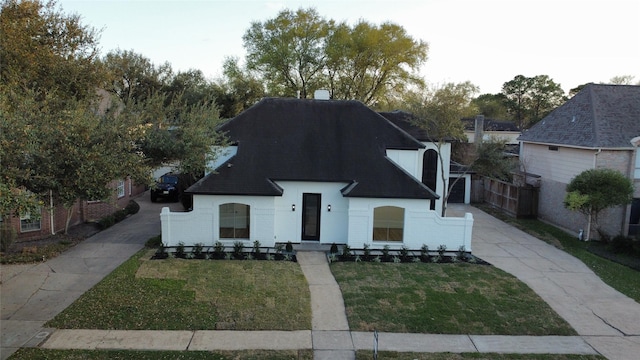 view of front of home with roof with shingles, a chimney, concrete driveway, and a front lawn