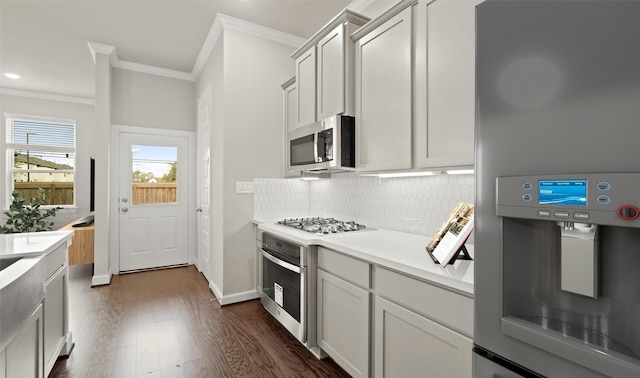 8821 Knoll Branch Dr, Houston, TX 77080 - kitchen with ornamental molding, light countertops, backsplash, dark wood finished floors, and appliances with stainless steel finishes