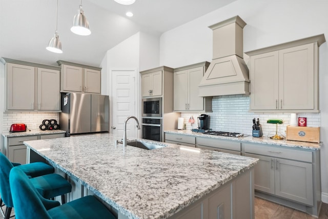 kitchen with a sink, appliances with stainless steel finishes, gray cabinets, and custom range hood