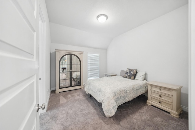 carpeted bedroom featuring lofted ceiling and baseboards