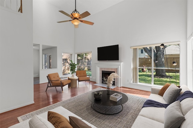 living room with wood finished floors, a healthy amount of sunlight, and a high ceiling