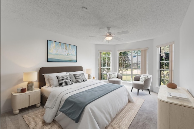 bedroom featuring light colored carpet, a ceiling fan, and a textured ceiling