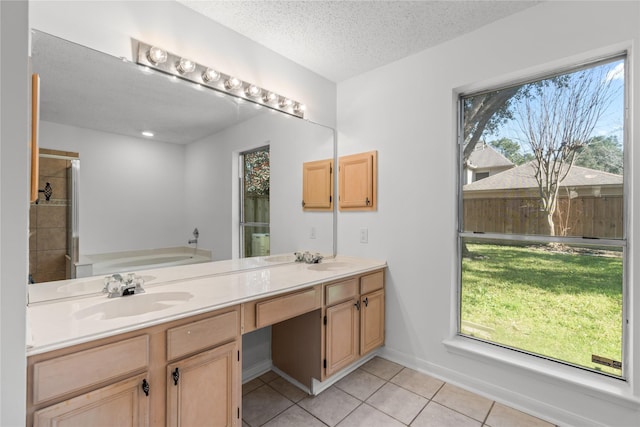 full bath featuring tile patterned floors, a garden tub, double vanity, and a sink
