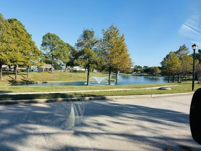 view of home's community with a lawn and a water view