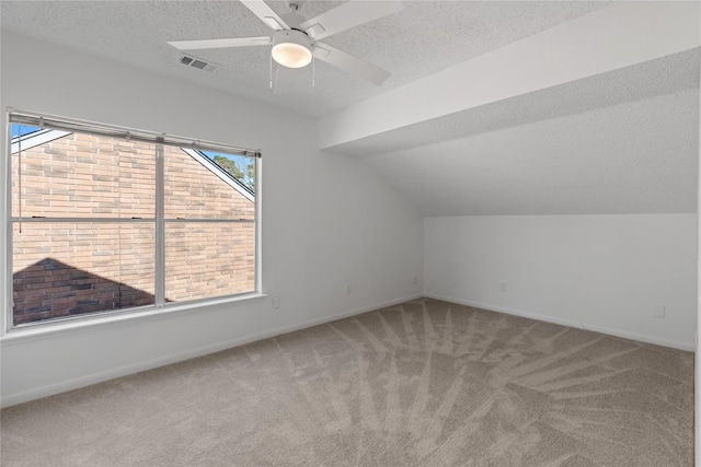 bonus room with a textured ceiling, visible vents, a ceiling fan, and carpet
