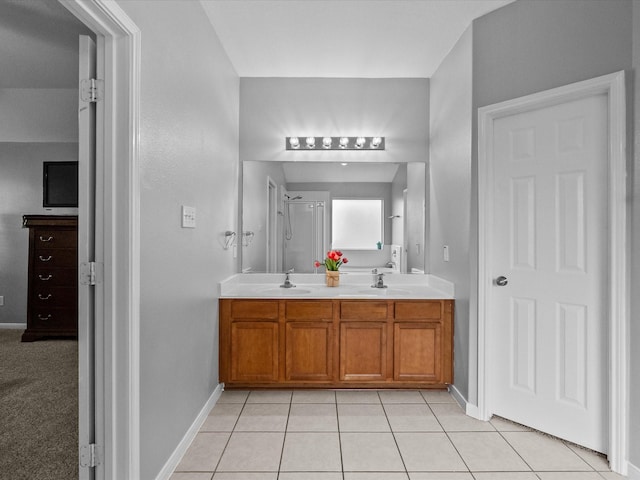 full bath featuring a sink, a shower, double vanity, and tile patterned floors