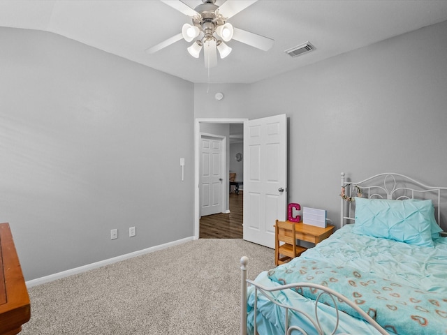 carpeted bedroom featuring lofted ceiling, baseboards, visible vents, and ceiling fan