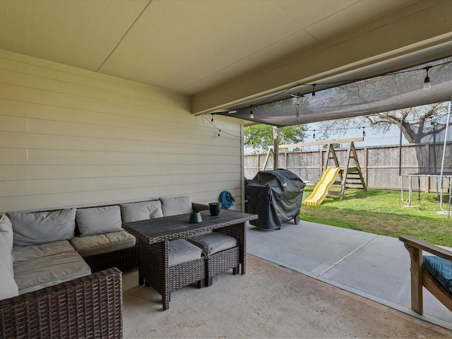 view of patio / terrace featuring area for grilling, an outdoor living space, a trampoline, a fenced backyard, and a playground