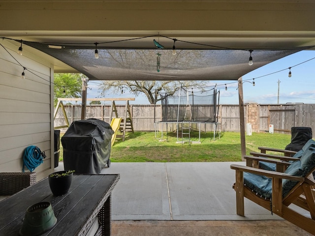 view of patio with a trampoline, a grill, a fenced backyard, and a playground