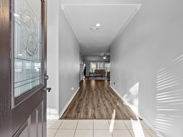 foyer featuring visible vents, ornamental molding, tile patterned flooring, baseboards, and ceiling fan