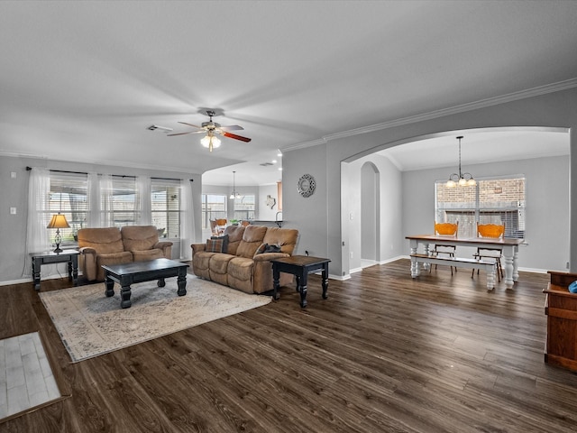 living room with visible vents, arched walkways, dark wood-style flooring, crown molding, and ceiling fan with notable chandelier