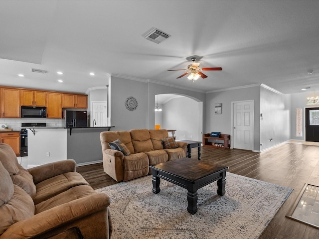 living room featuring arched walkways, visible vents, ceiling fan with notable chandelier, and wood finished floors