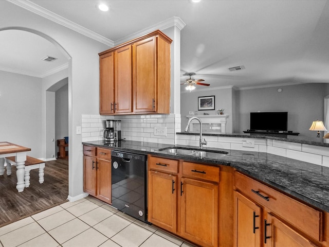 kitchen featuring visible vents, a sink, black dishwasher, backsplash, and arched walkways