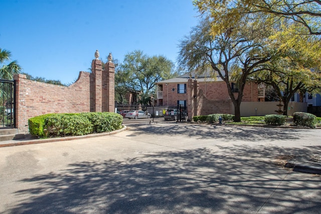 view of road with curbs, a gated entry, and a gate