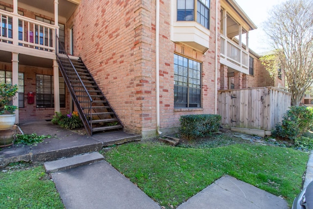 property entrance with brick siding and a yard