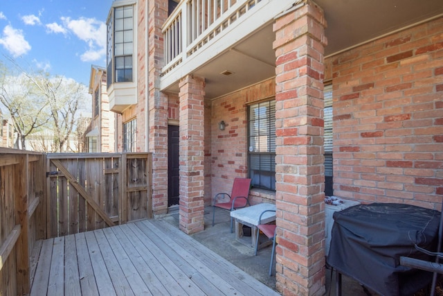 deck featuring a gate, grilling area, and fence