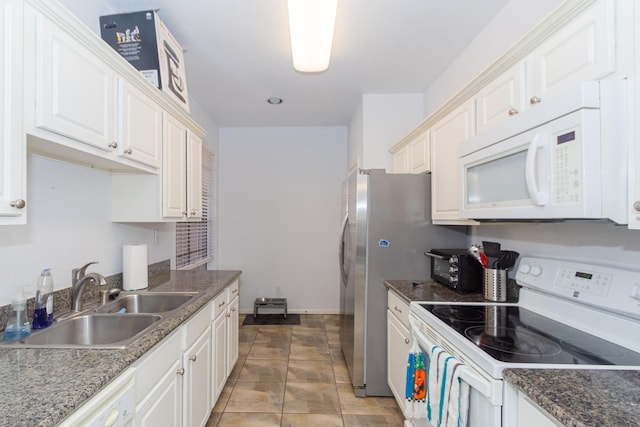 kitchen featuring white appliances, white cabinetry, baseboards, and a sink