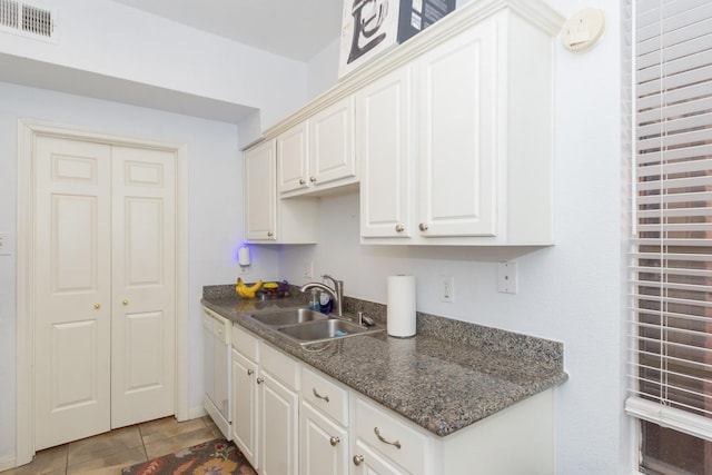 kitchen featuring visible vents, a sink, white cabinets, light tile patterned flooring, and dishwasher