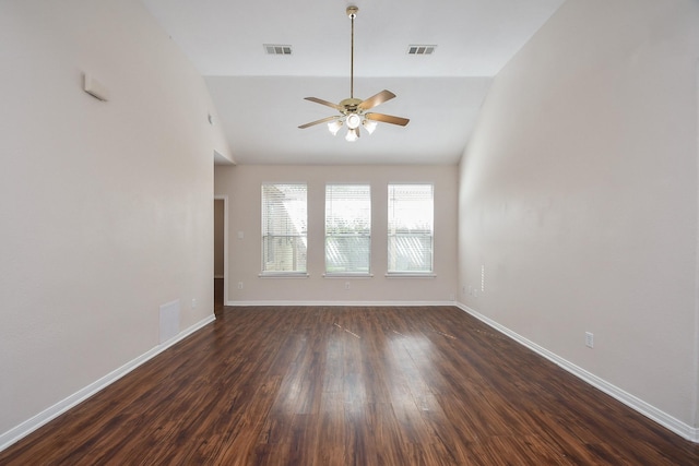 spare room with dark wood-style floors, visible vents, baseboards, lofted ceiling, and ceiling fan