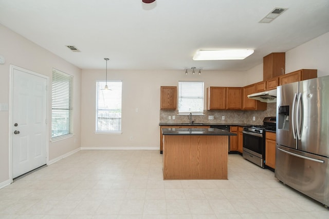 kitchen featuring under cabinet range hood, stainless steel appliances, visible vents, and a sink