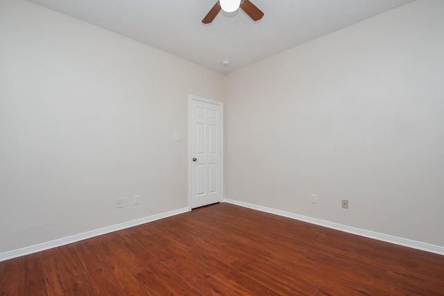 empty room featuring baseboards, ceiling fan, and dark wood-style flooring