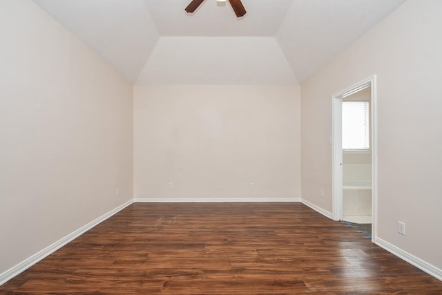 empty room featuring baseboards, lofted ceiling, dark wood finished floors, and a ceiling fan