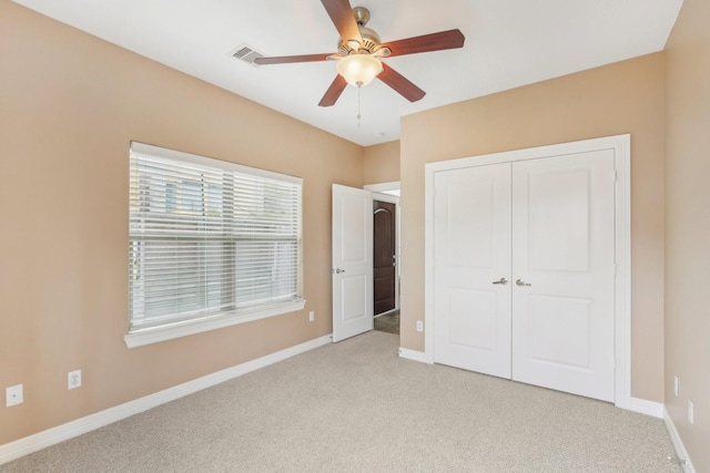 unfurnished bedroom featuring visible vents, baseboards, ceiling fan, light colored carpet, and a closet