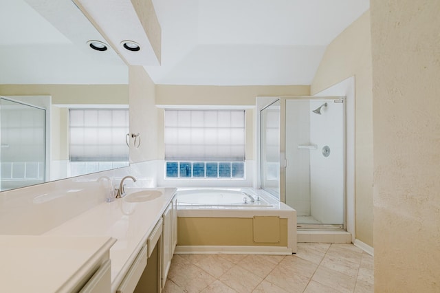 bathroom with vanity, a shower stall, a bath, and a textured wall