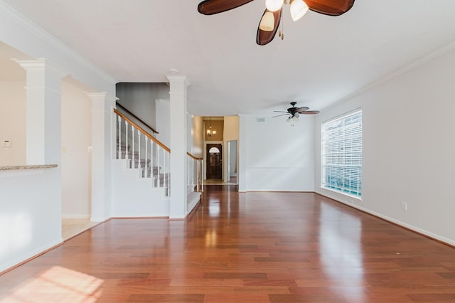 unfurnished living room featuring stairway, crown molding, a ceiling fan, and wood finished floors