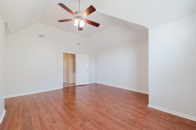 spare room with a ceiling fan, visible vents, ornamental molding, vaulted ceiling, and light wood-type flooring