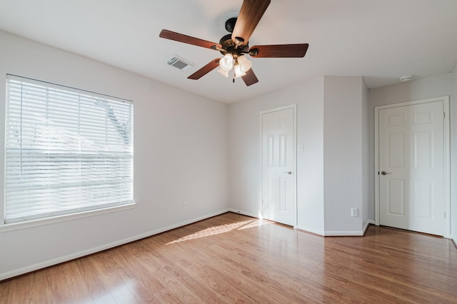 unfurnished bedroom featuring a ceiling fan, visible vents, baseboards, and light wood-type flooring