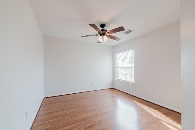 empty room with visible vents, baseboards, a ceiling fan, and wood finished floors