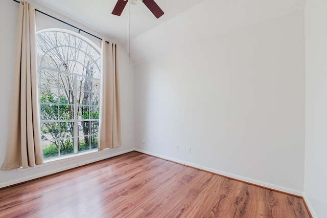 unfurnished room featuring plenty of natural light, ceiling fan, and wood finished floors