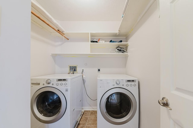 washroom with light tile patterned floors, washing machine and dryer, and laundry area