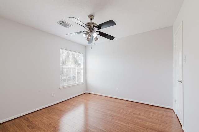 empty room with visible vents, baseboards, light wood-style flooring, and a ceiling fan