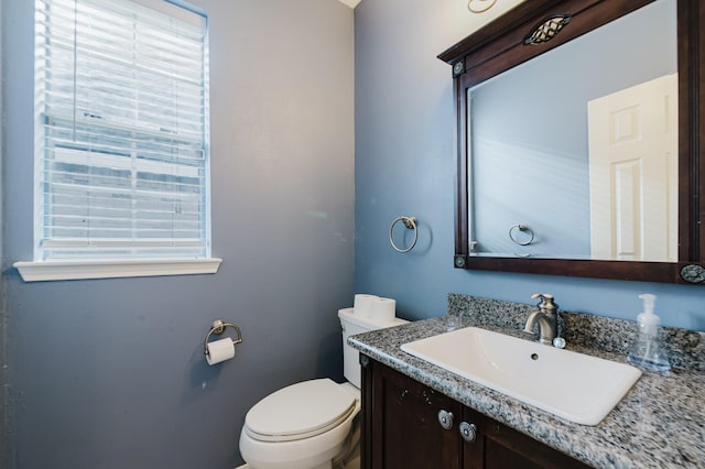 half bathroom featuring toilet and vanity